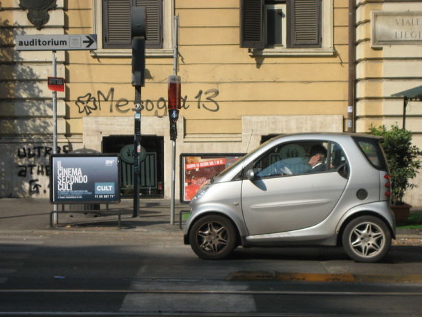 person driving tiny smart car in Italy