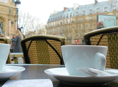 receipt and two cups of coffee on outdoor dining table in Paris