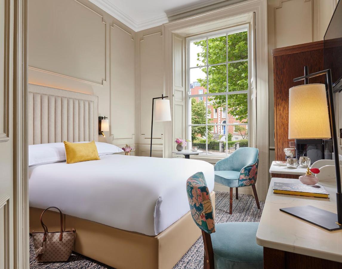 bed and floral chairs in beige hotel room